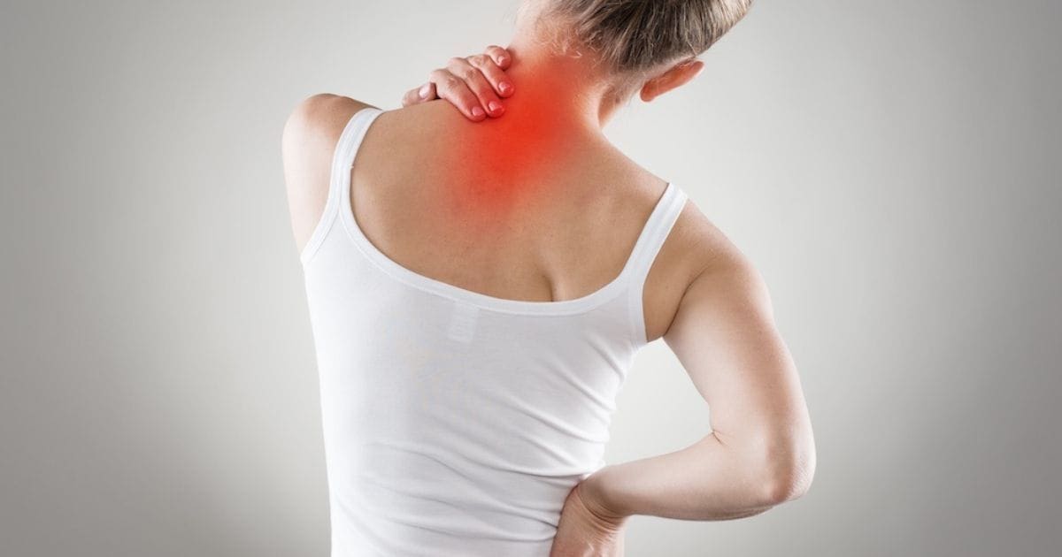 donna di spalle che stira la schiena con il dolore in rosso