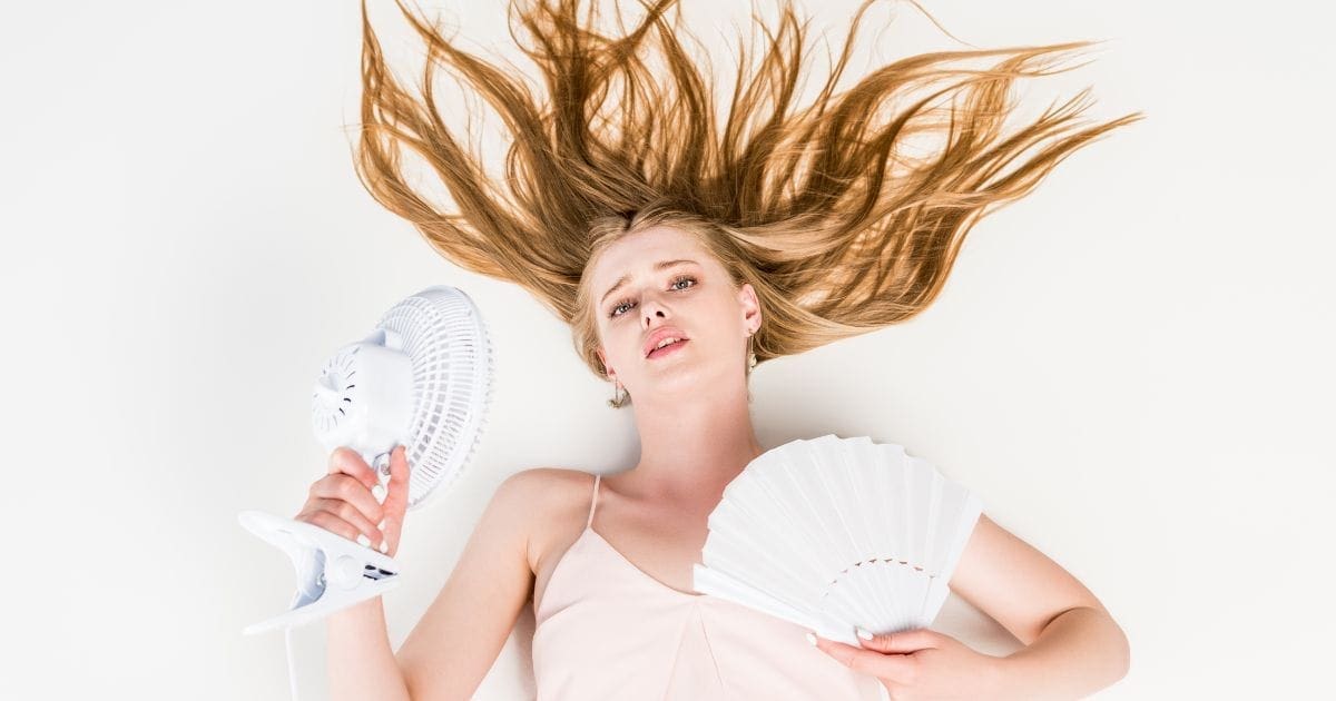 ragazza distesa sul letto che soffre il caldo