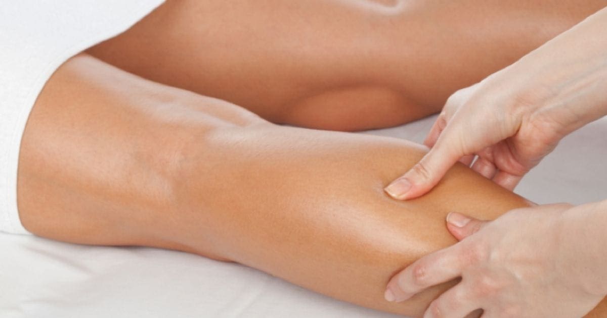 una persona massaggia le gambe gonfie di un'altra distesa su un lettino