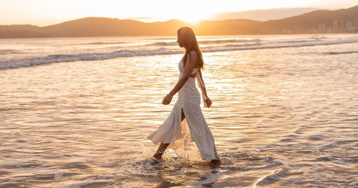 donna passeggia sulla spiaggia con gambe leggere