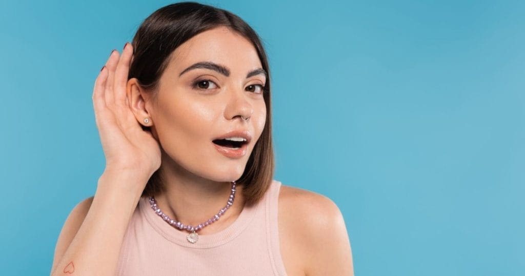 ragazza con mano sull'orecchio nell'atto di ascoltare