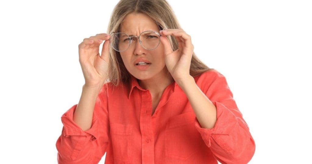 donna con miodesopsia allunga gli occhiali perché non vede bene