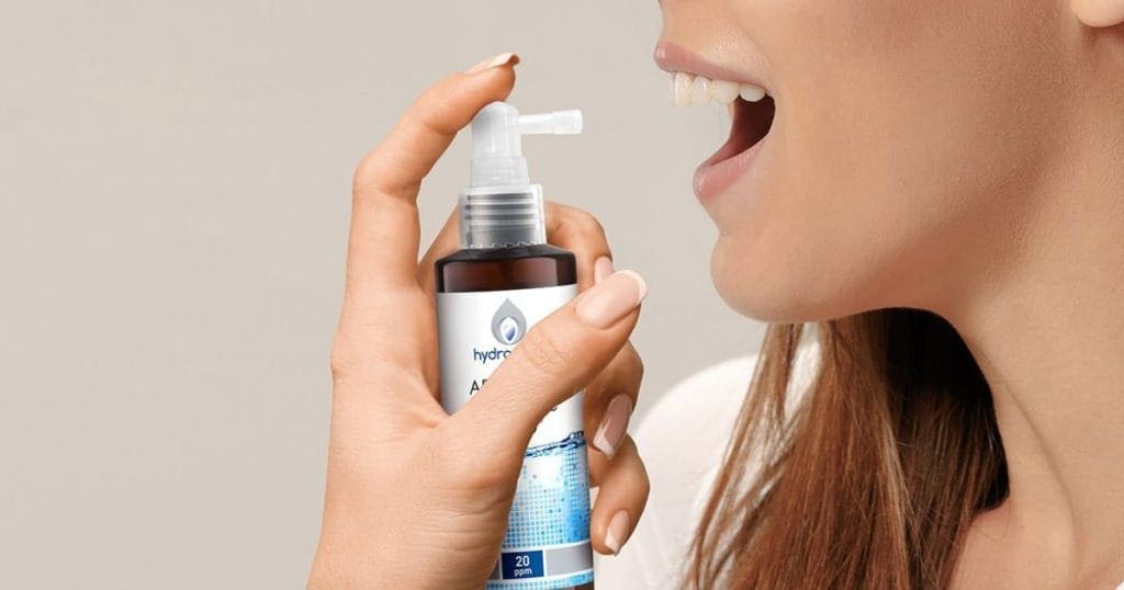 ragazza spruzza in bocca un Colloidale Puro