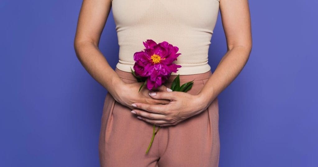 donna tiene un mazzo di fiori all'altezza delle parti intime a indicare il periodo della premenopausa