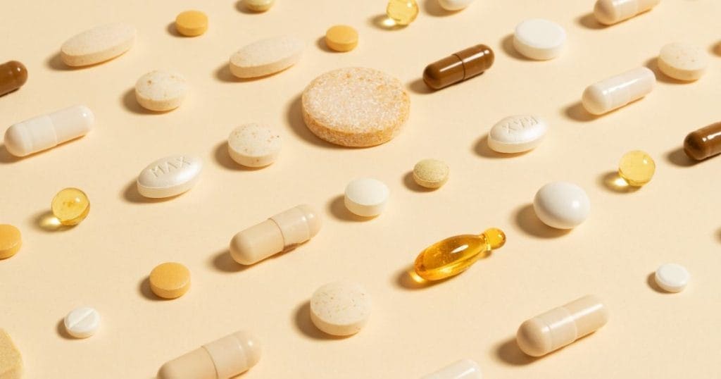 diverse forme di integratori in pastiglie su uno sfondo giallo